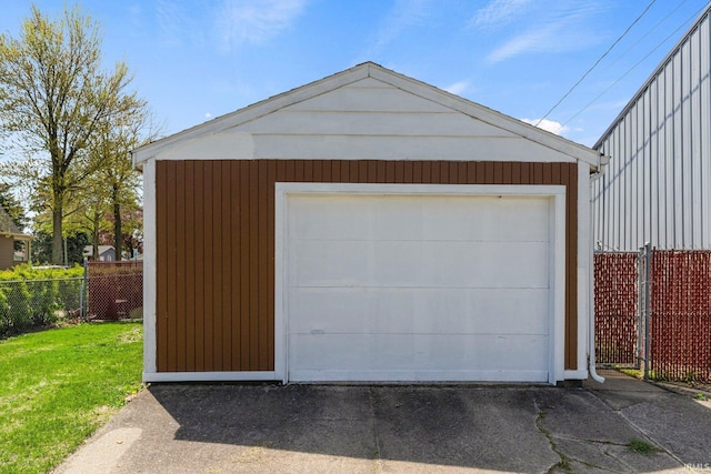 detached garage featuring fence and driveway