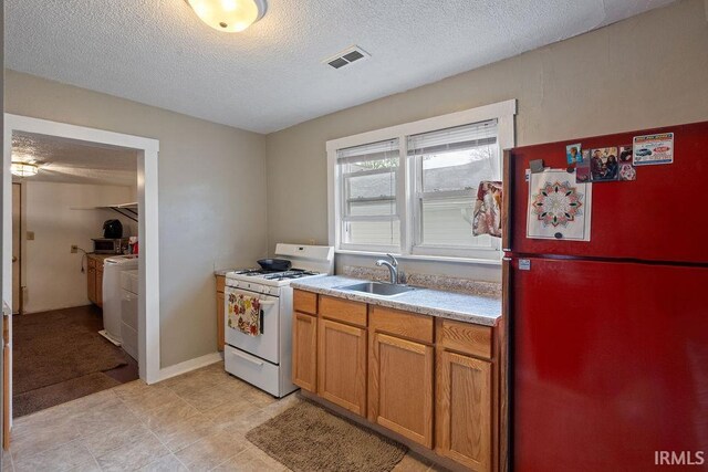 730 S Bell St, Kokomo, IN 46902 - kitchen with visible vents, a sink, light countertops, freestanding refrigerator, and white range with gas cooktop