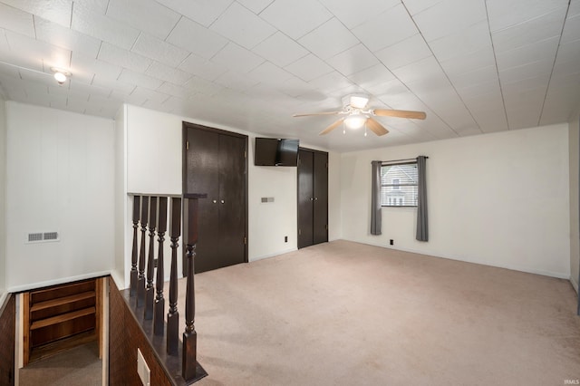 unfurnished room with ceiling fan, carpet, and visible vents