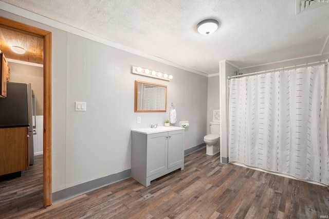 full bath with crown molding, a textured ceiling, wood finished floors, and toilet