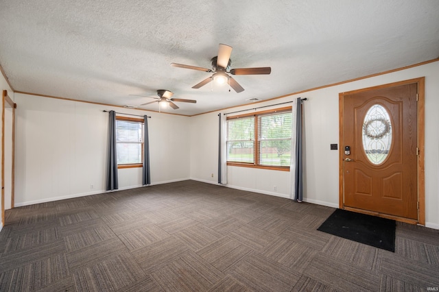 foyer featuring baseboards, ceiling fan, ornamental molding, and dark colored carpet