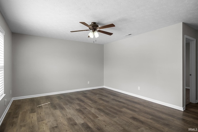 unfurnished room featuring visible vents, dark wood-style flooring, baseboards, a textured ceiling, and a ceiling fan