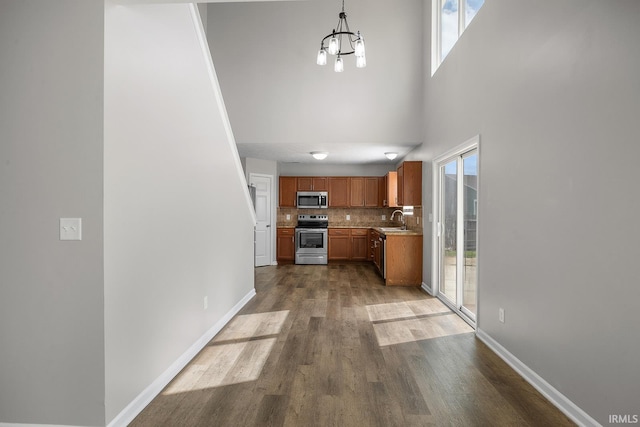 interior space featuring a sink, a high ceiling, wood finished floors, and a chandelier