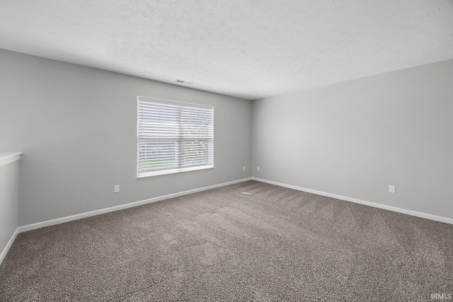 empty room featuring baseboards, carpet flooring, a textured ceiling, and visible vents