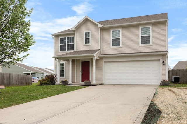 traditional home featuring fence, an attached garage, a front lawn, cooling unit, and driveway