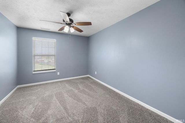 carpeted spare room featuring baseboards, a ceiling fan, and a textured ceiling