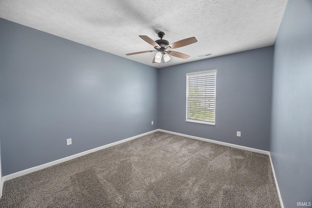 carpeted empty room with baseboards, ceiling fan, a textured ceiling, and visible vents