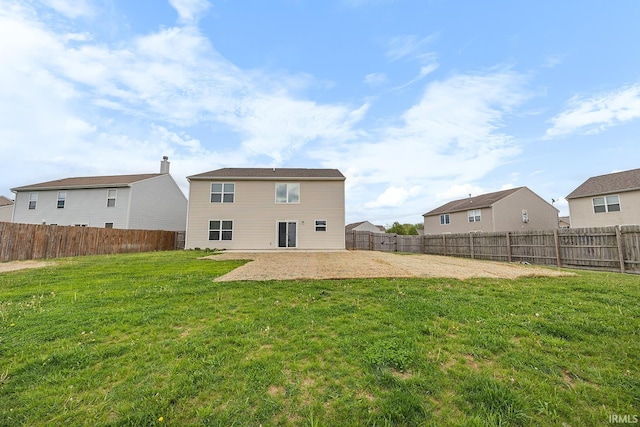 back of house with a fenced backyard, a patio, and a lawn