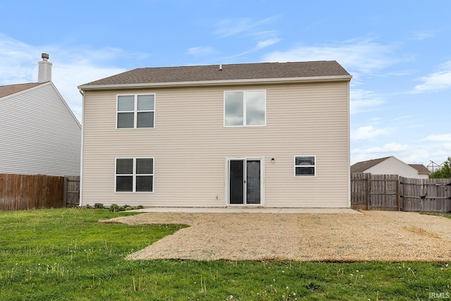 rear view of house featuring a fenced backyard and a yard