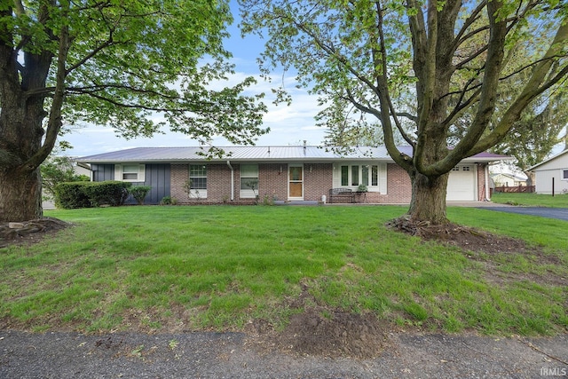 single story home with aphalt driveway, a front yard, brick siding, board and batten siding, and an attached garage