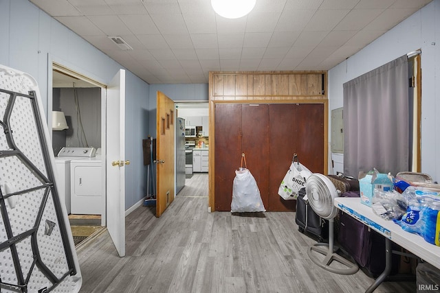 interior space featuring visible vents, light wood-style flooring, and washing machine and clothes dryer