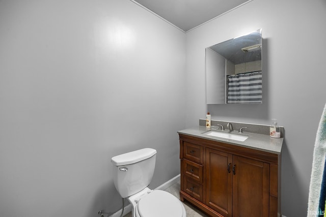 bathroom with vanity, ornamental molding, baseboards, and toilet