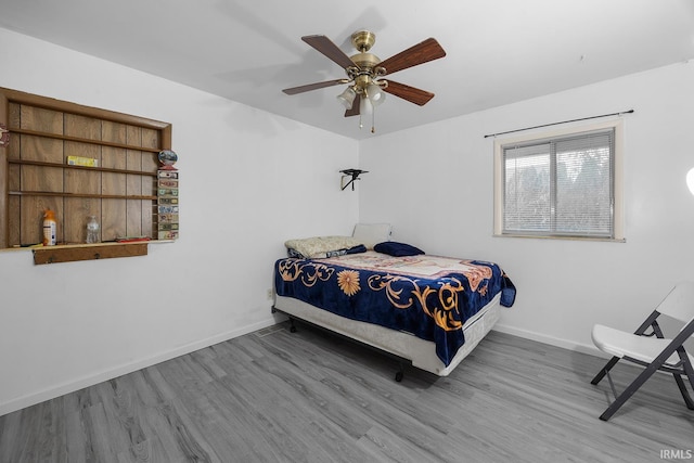bedroom featuring baseboards, ceiling fan, and wood finished floors