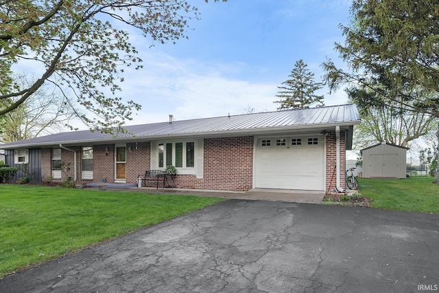 ranch-style home featuring driveway, metal roof, a front yard, brick siding, and an attached garage