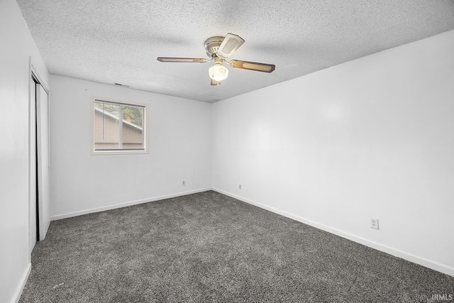 empty room featuring ceiling fan, a textured ceiling, visible vents, baseboards, and dark carpet