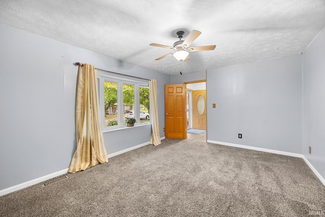 empty room featuring a textured ceiling, visible vents, ceiling fan, and carpet