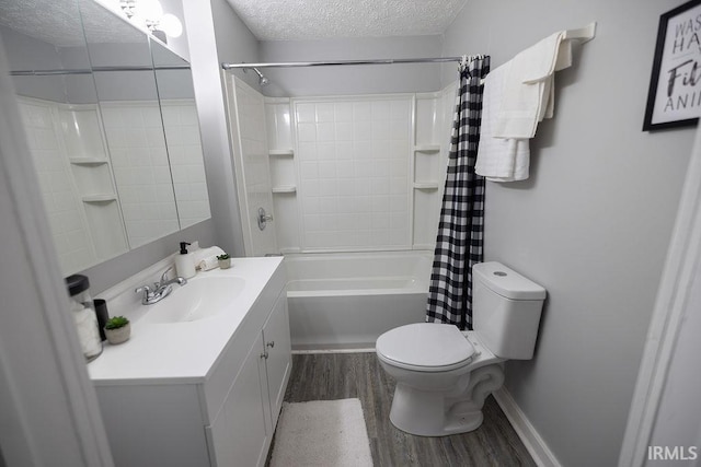 bathroom with vanity, shower / bath combo with shower curtain, wood finished floors, toilet, and a textured ceiling