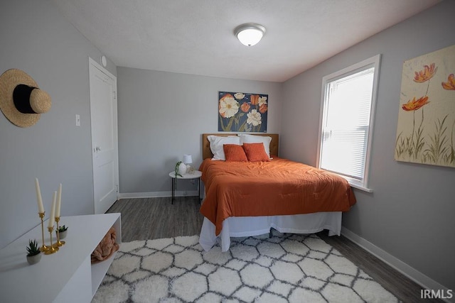 bedroom featuring baseboards and wood finished floors