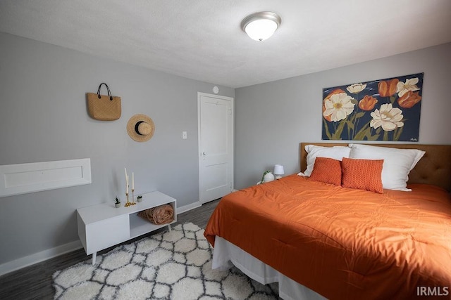 bedroom with baseboards and wood finished floors