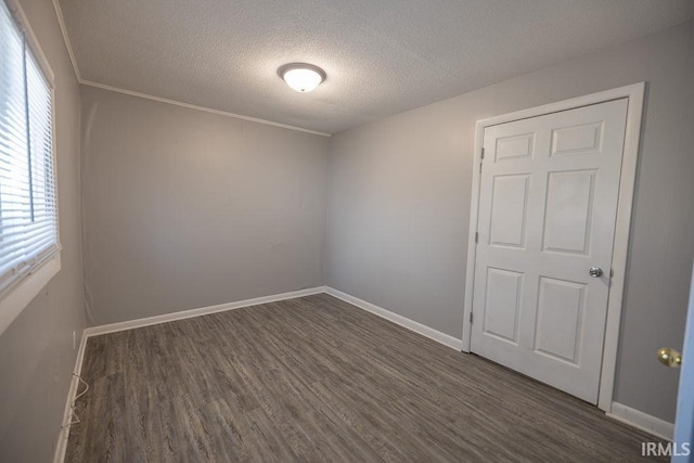 spare room with baseboards, a textured ceiling, and wood finished floors