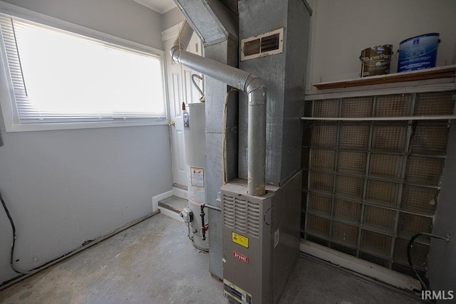 utilities with visible vents, heating unit, and gas water heater