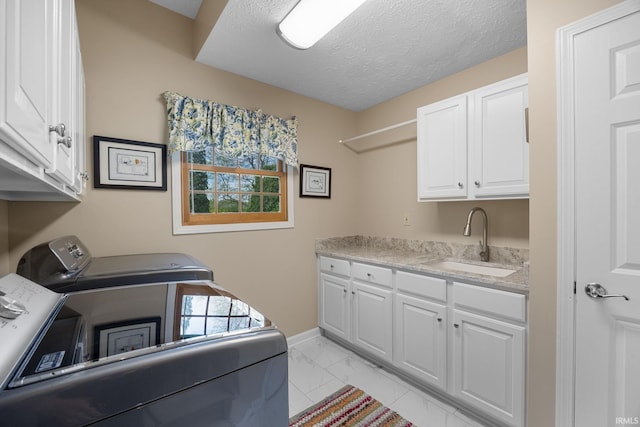 clothes washing area with washer and dryer, cabinet space, a sink, marble finish floor, and baseboards