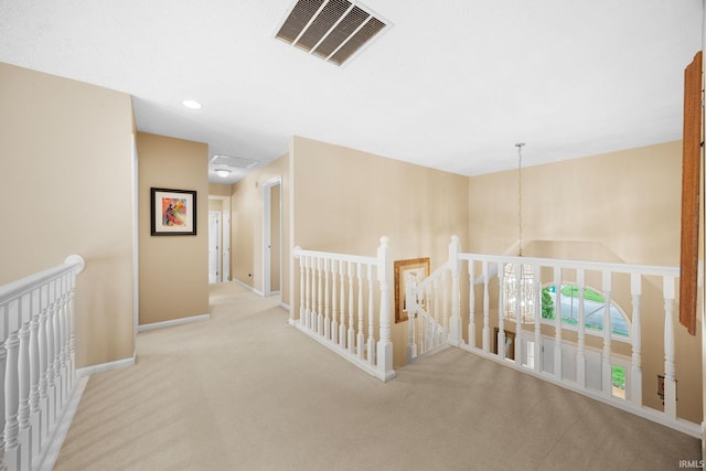 corridor with visible vents, carpet floors, baseboards, an upstairs landing, and recessed lighting