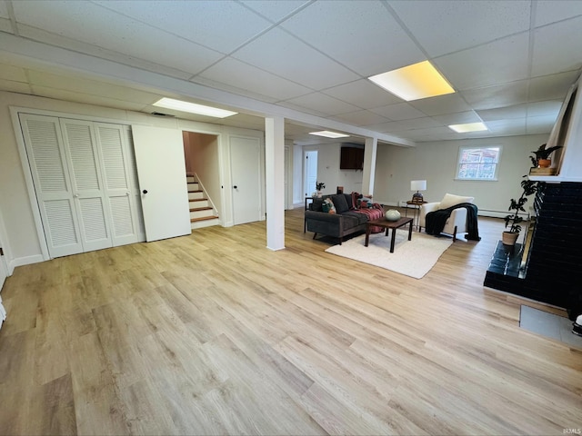 2031 Alton Dr, Kokomo, IN 46901 - living area featuring stairs, a drop ceiling, wood finished floors, and a baseboard radiator