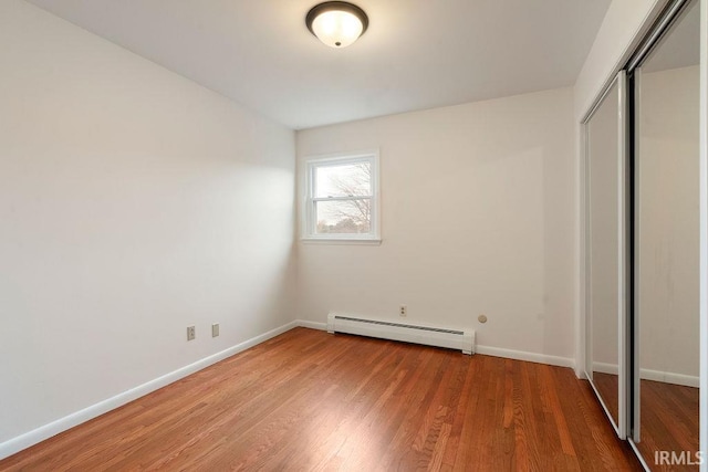 2031 Alton Dr, Kokomo, IN 46901 - unfurnished bedroom with baseboards, a baseboard heating unit, light wood-style flooring, and a closet