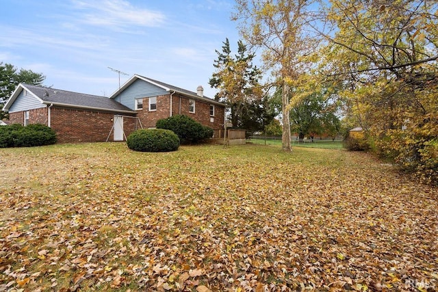 2031 Alton Dr, Kokomo, IN 46901 - view of side of property featuring a lawn, brick siding, fence, and a chimney