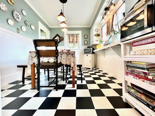 interior space with tile patterned floors, ornamental molding, and a wainscoted wall