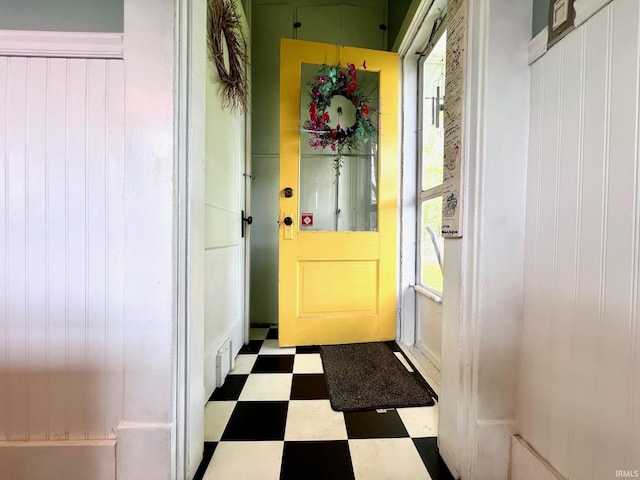interior space with tile patterned floors, visible vents, and wood walls