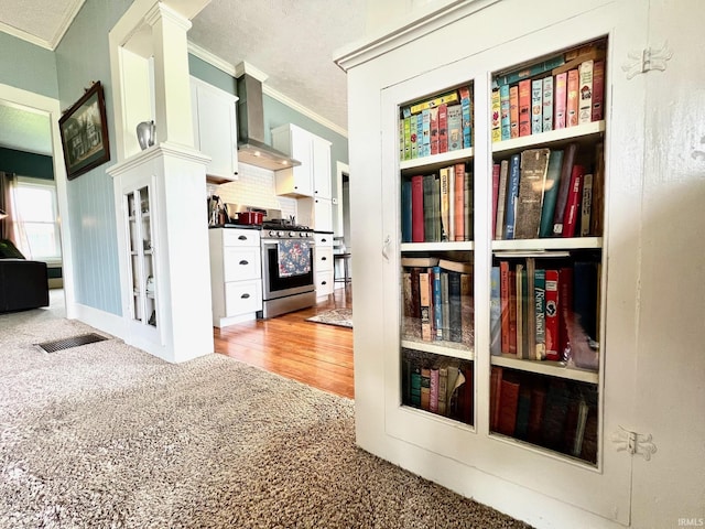 hall featuring ornamental molding, carpet, a textured ceiling, and visible vents