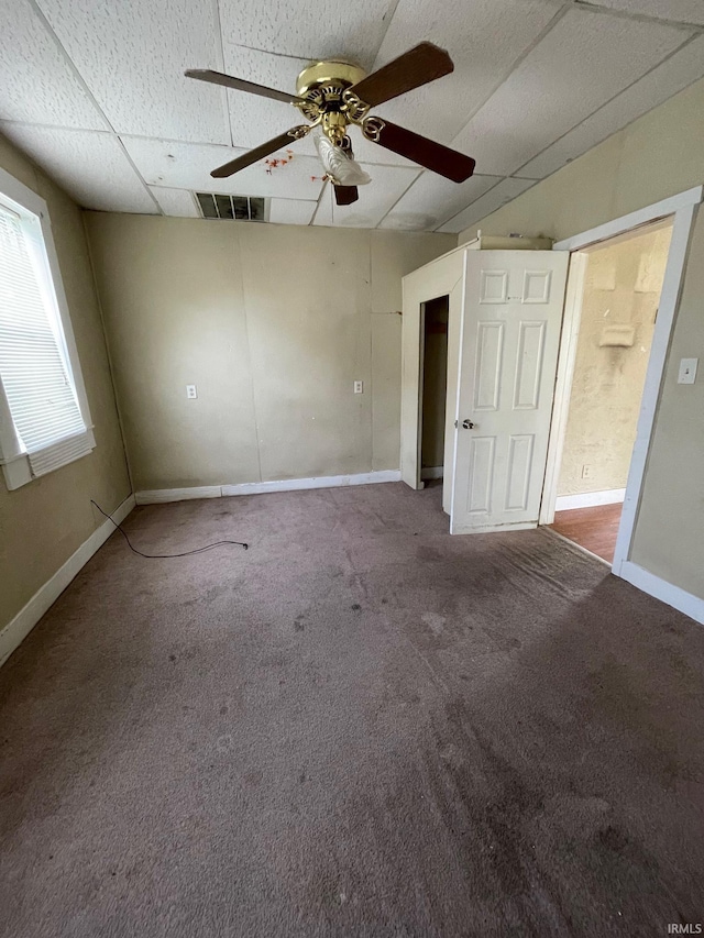 interior space featuring visible vents, carpet flooring, baseboards, and a drop ceiling