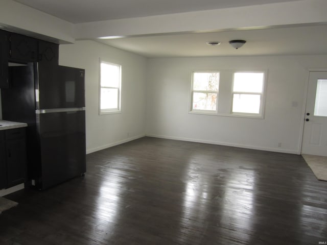 unfurnished living room featuring baseboards, dark wood-style floors, and visible vents