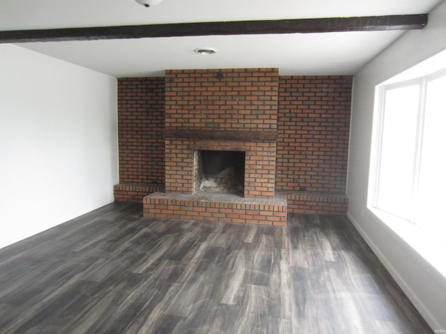 unfurnished living room with a fireplace, baseboards, beam ceiling, and wood finished floors