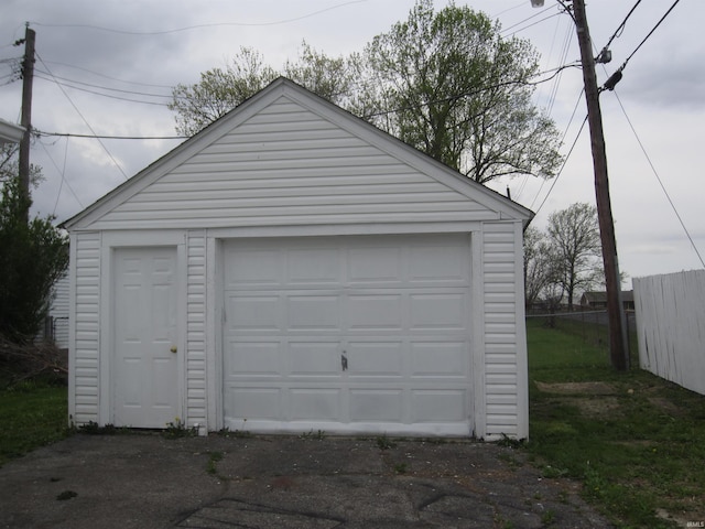 detached garage with fence and driveway