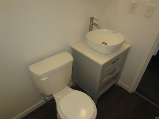 bathroom with vanity, baseboards, toilet, and wood finished floors
