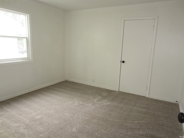 carpeted spare room with baseboards