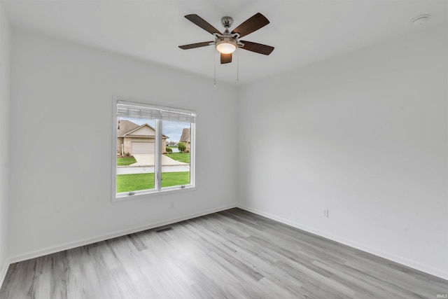 spare room with baseboards, ceiling fan, and wood finished floors