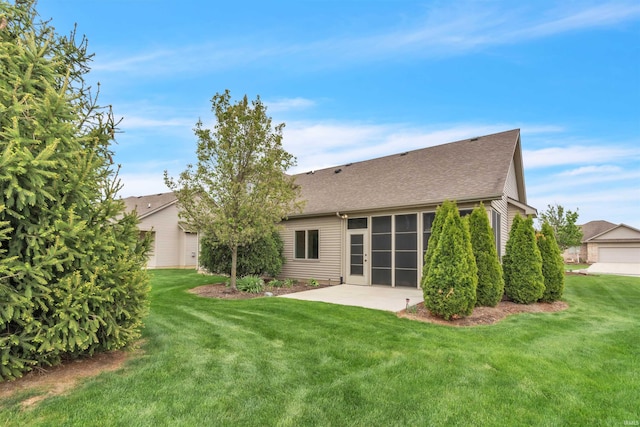 back of property with a patio area, roof with shingles, and a yard