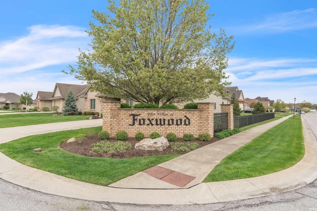 community sign featuring a yard and a residential view