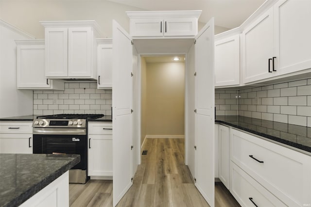 1724 28th St, Bedford, IN 47421 - kitchen featuring stainless steel gas range, light wood finished floors, white cabinets, and decorative backsplash