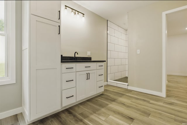 1724 28th St, Bedford, IN 47421 - bathroom with walk in shower, wood finished floors, baseboards, and vanity