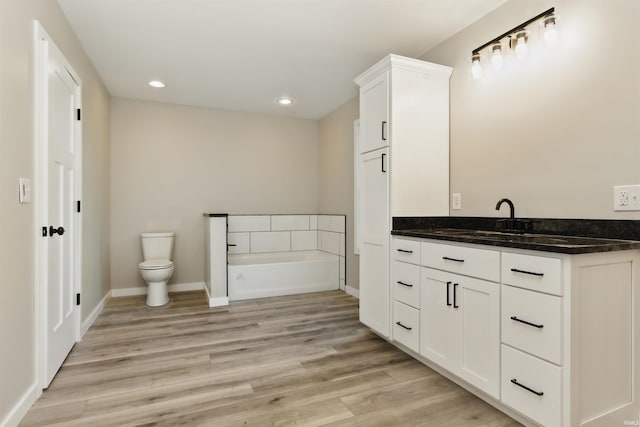 1724 28th St, Bedford, IN 47421 - bathroom with a bath, vanity, toilet, wood finished floors, and recessed lighting