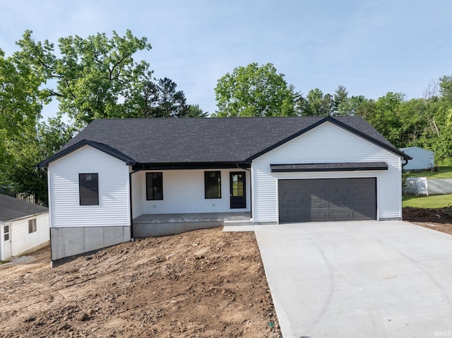 1724 28th St, Bedford, IN 47421 - modern inspired farmhouse featuring an attached garage, covered porch, concrete driveway, and a shingled roof