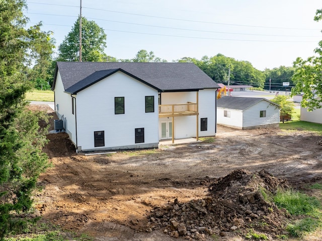 1724 28th St, Bedford, IN 47421 - rear view of house with french doors, dirt driveway, central air condition unit, roof with shingles, and a balcony