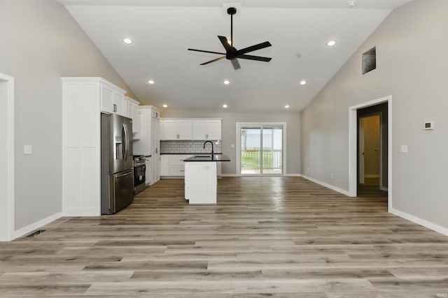 1724 28th St, Bedford, IN 47421 - kitchen featuring stainless steel appliances, open floor plan, a ceiling fan, dark countertops, and high vaulted ceiling