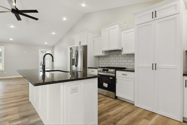 1724 28th St, Bedford, IN 47421 - kitchen featuring appliances with stainless steel finishes, a sink, backsplash, vaulted ceiling, and light wood-style flooring