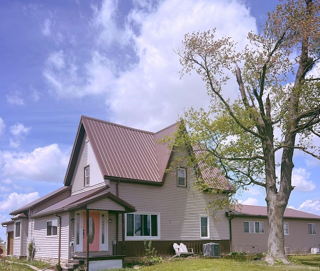 exterior space with central AC and metal roof